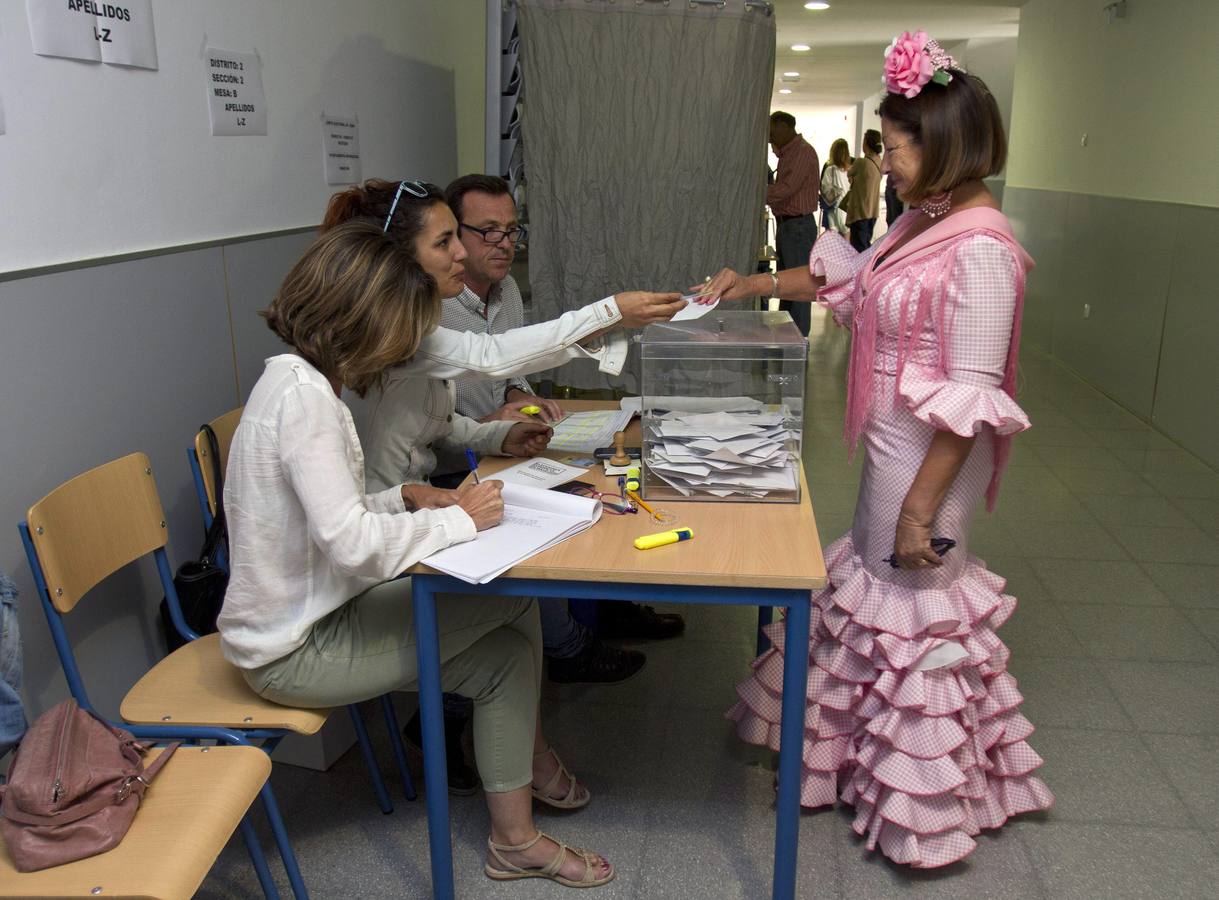 Una mujer vestida de flamenca ejerce su derecho a voto.