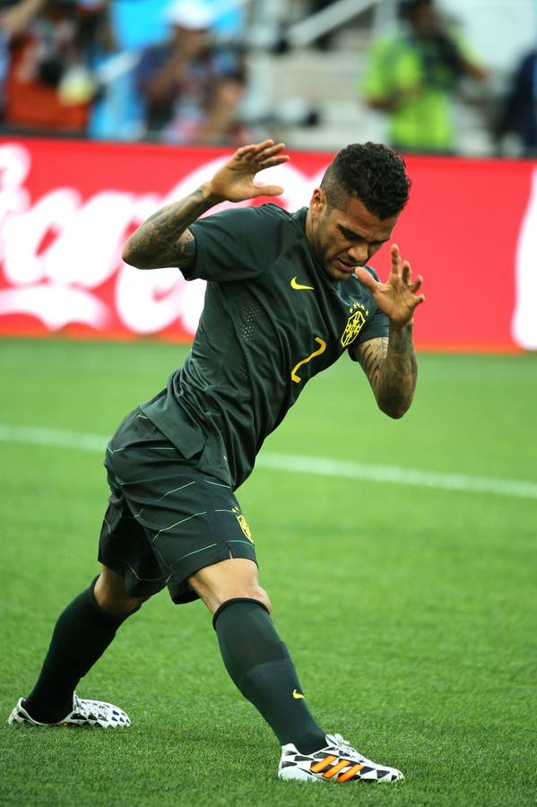 Daniel Alves realiza algunos estiramientos. El lateral pone a punto su físico para evitar sustos