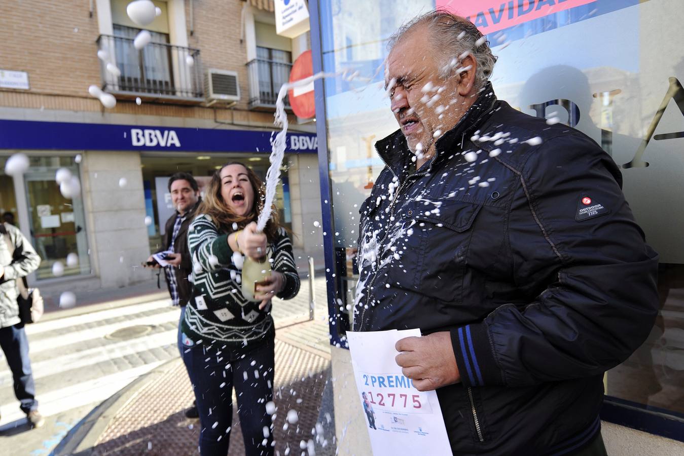 José Ramón Núñez (d), responsable de la administración de loterías situada en la calle Constitución de Mora (Toledo), celebra la venta del segundo premio.