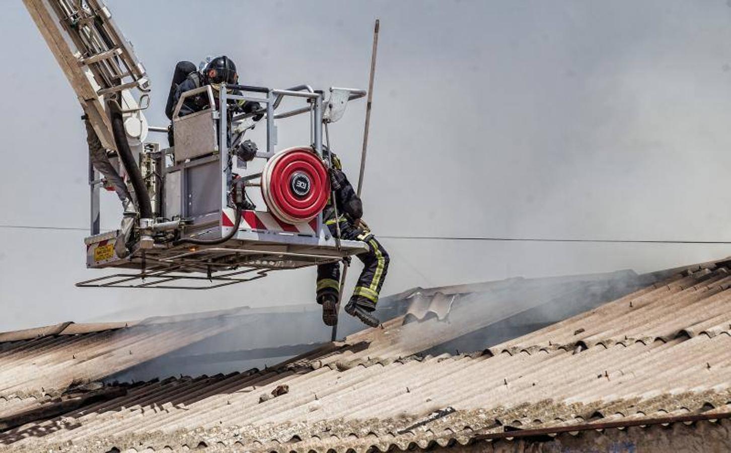 Los bomberos trabajan para extinguir un incendio en una nave abandonada