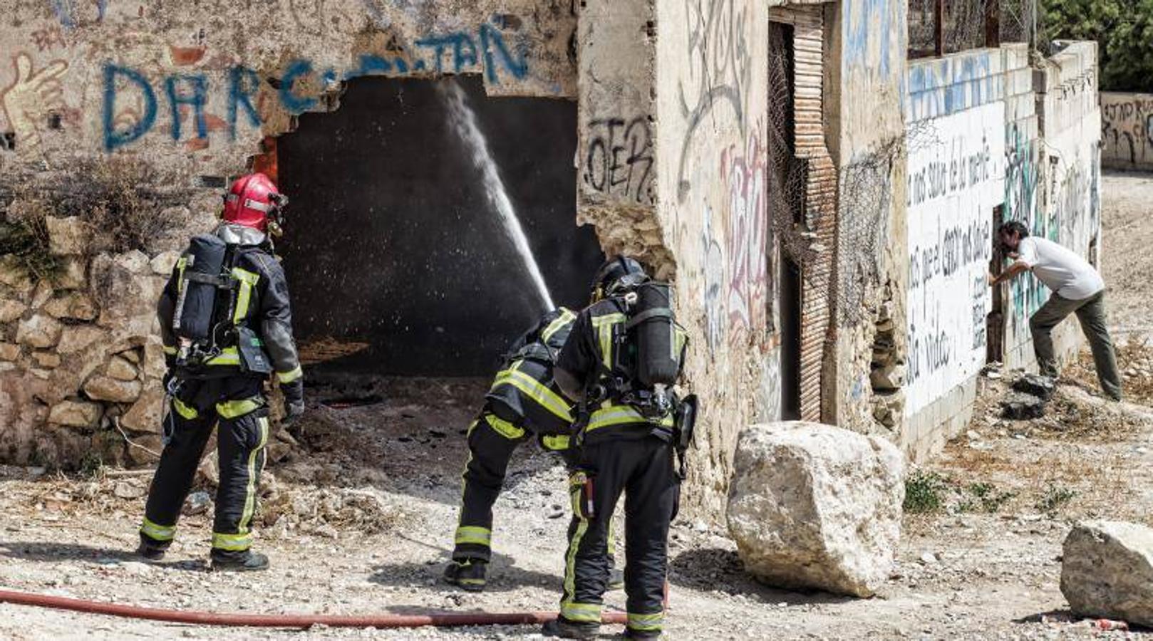 Los bomberos trabajan para extinguir un incendio en una nave abandonada