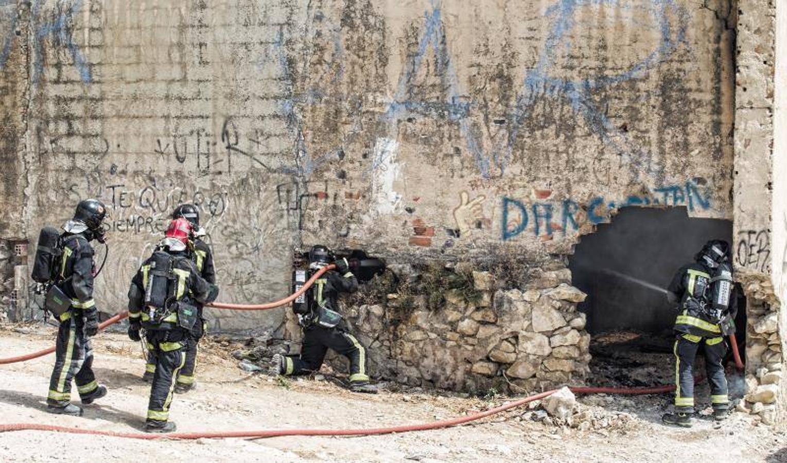 Los bomberos trabajan para extinguir un incendio en una nave abandonada