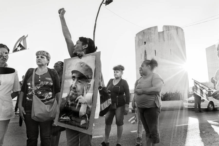 Una mujer muestra orgullosa un cartel con la foto de Castro.