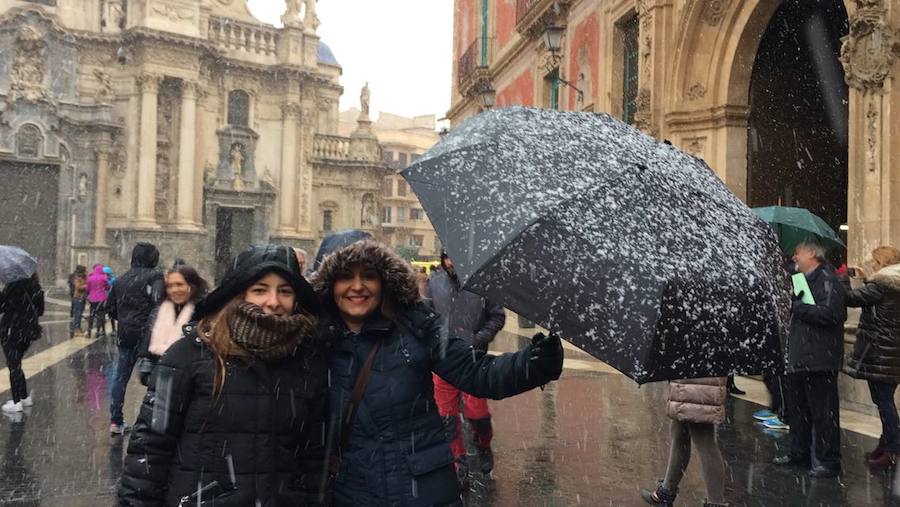 Dos chicas posan para una foto en la plaza de Cardenal Belluga.