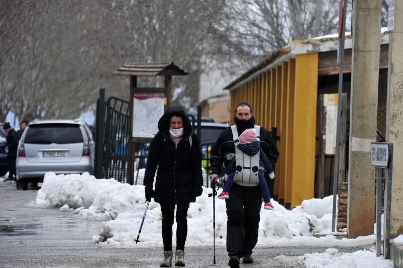Una pareja y su hija paseando por la carretera nevada de Bullas.