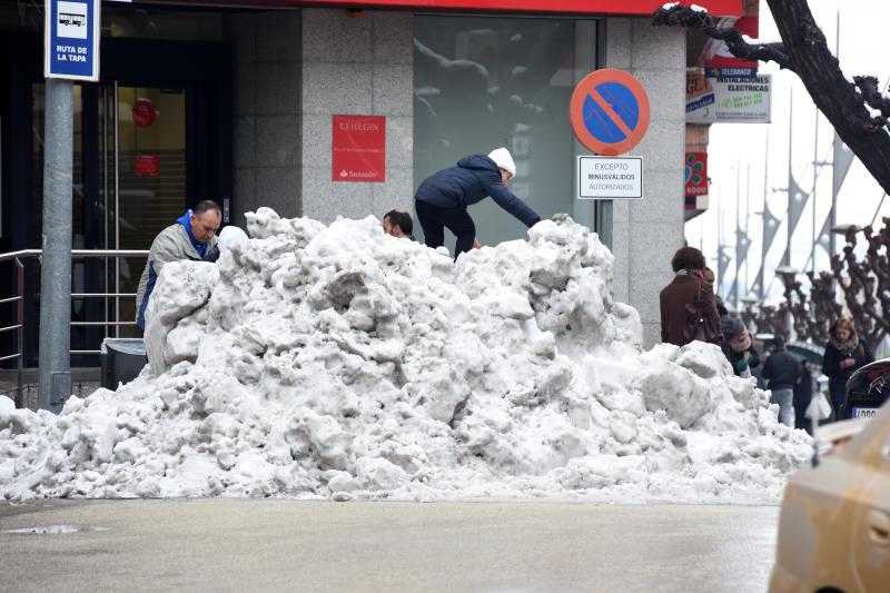 Un niño juega con un montón de nieve en Cehegín.