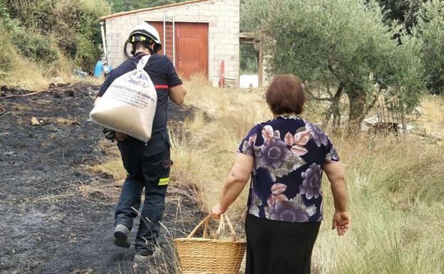 Un bombero acompaña a una vecina de regreso a su casa en Yeste.