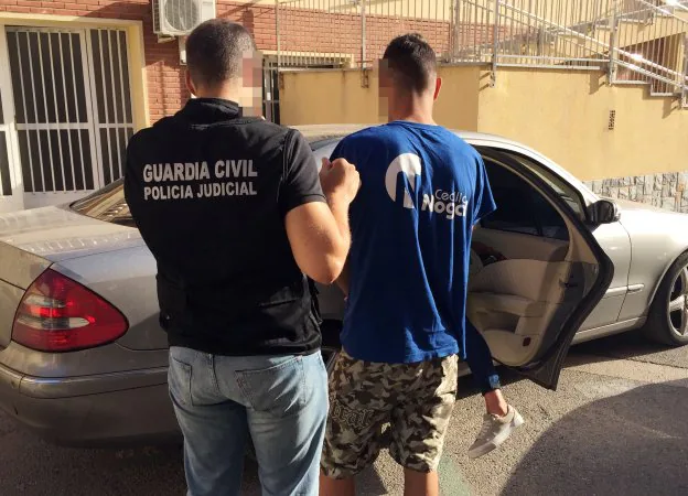 Uno de los investigadores de la Guardia Civil, conduciendo a uno de los tres sospechosos hasta el juzgado de San Javier.