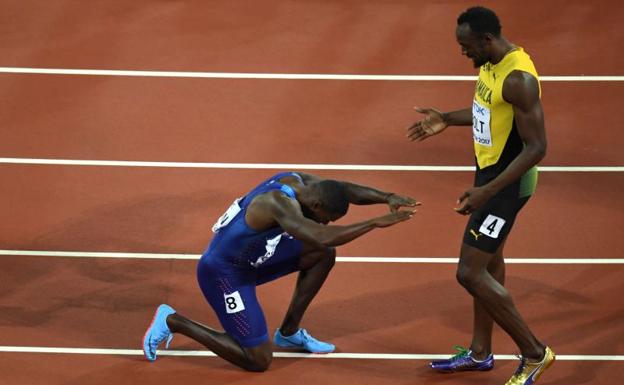 Justin Gatlin se arrodilla ante Usain Bolt. 