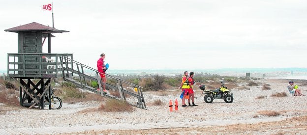 Tres vigilantes contratados por Protección Civil, en la playa de la Torre Derribada, en el término municipal de San Pedro del Pinatar.
