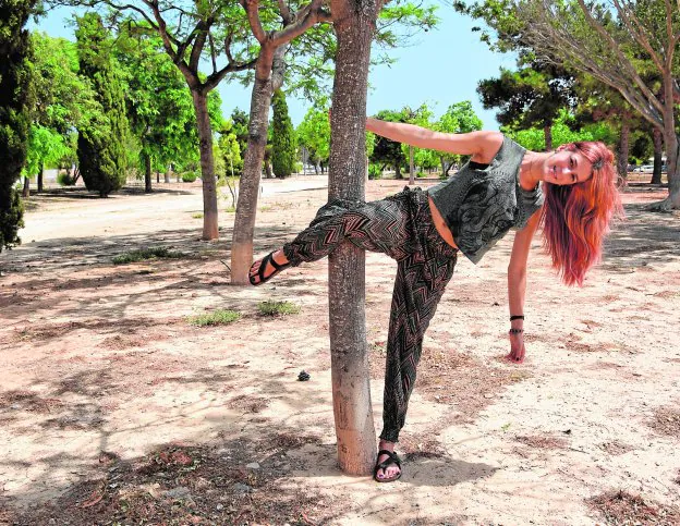 Lara Berzosa emulando un movimiento de Pole Dance en el árbol de un parque de Santiago de la Ribera.