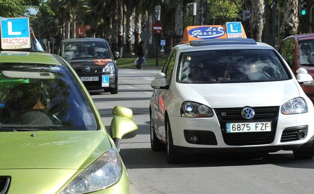 Varios coches de autoescuela circulan por Murcia.