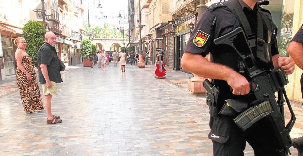 Un policía nacional, con un arma larga, ayer en la calle Santa Florentina de Cartagena.