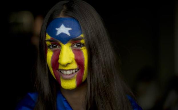 Una chica con la bandera catalana pintada en su cara.