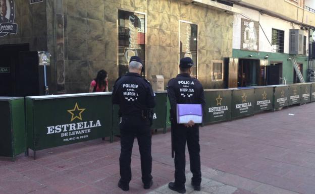 Dos agentes de la Policía Local de Murcia inspeccionan barras instaladas en el Bando de la Huerta.