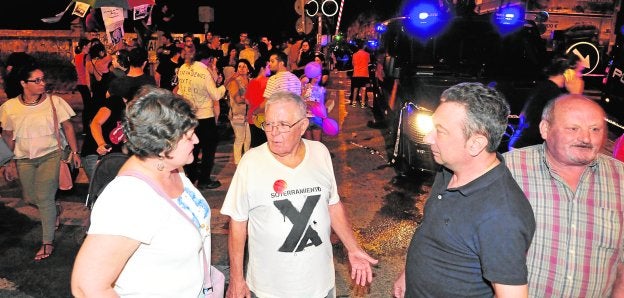 Joaquín Concentras (c), portavoz de la Plataforma, anoche durante la concentración en el paso a nivel de Santiago el Mayor.