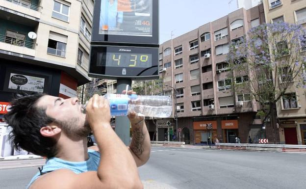 Un joven bebiendo agua en un día caluroso.