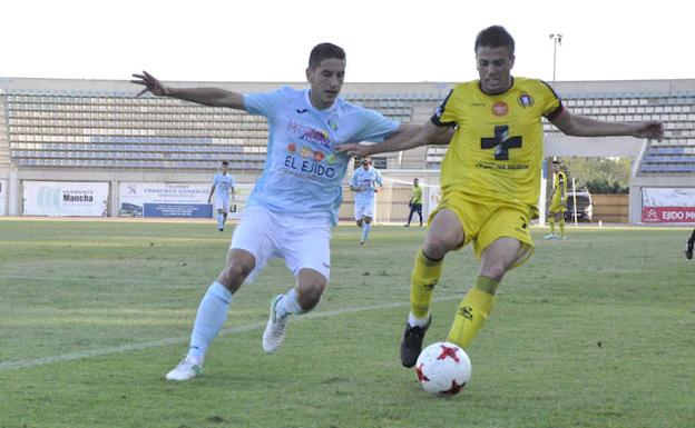 Un jugador del Lorca Deportiva y uno de El Ejido pelean por un balón.