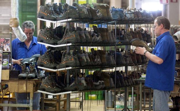 Operarios inspeccionando botas recién fabricadas. 