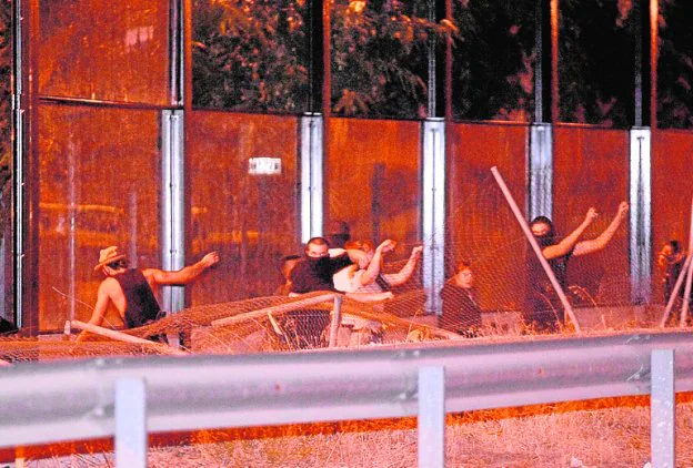 Manifestantes atacando las pantallas del 'muro', anoche. 