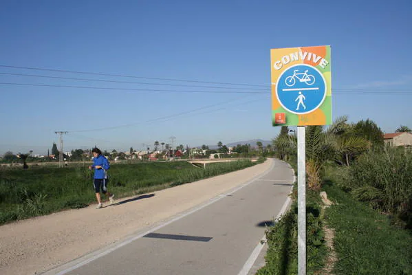 Imagen secundaria 2 - Un ciclista a punto de adelantar a un jinete, en el tramo del carril-bici que pasa junto a Alcantarilla, un poste señalizador en la contraparada y una señal con indicaciones.
