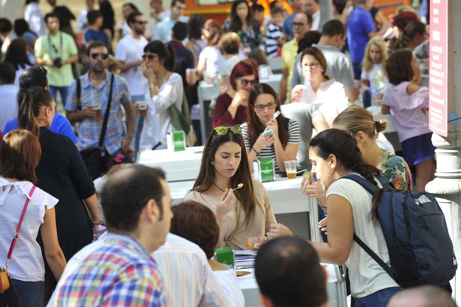 Los visitantes disfrutan de distintas tapas y platos especiales en un paseo gastronómico al aire libre