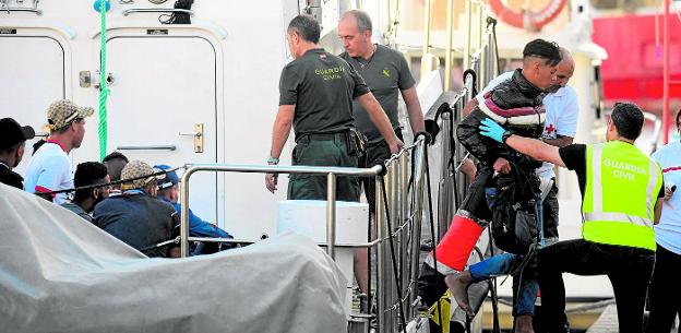 Algunos de los inmigrantes irregulares llegados en la tarde de ayer descendiendo de la patrullera de la Guardia Civil, en Cartagena.