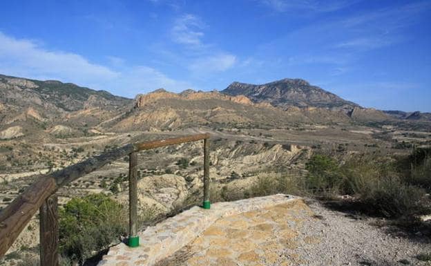 Las crestas rojizas de la Sierra del Águila y la inconfundible silueta de La Pila en forma de silla de montar, desde el mirador de La Loma.