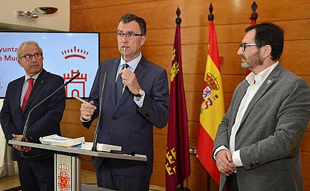 El alcalde muestra el bastoncillo incluido en el kit para realizar el test genético; a su lado, el concejal de Salud, Felipe Coello, y el decano de Veterinaria, Gaspar Ros.