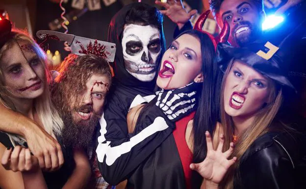 Jóvenes se divierten en una fiesta de Halloween. 