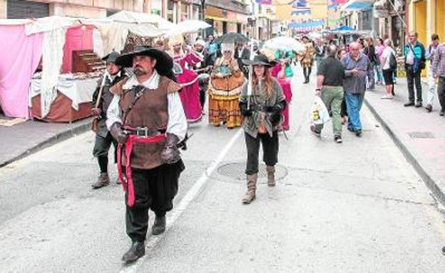 Tres soldados de época recorren la calle del Duque, durante las primeras horas de mercado.