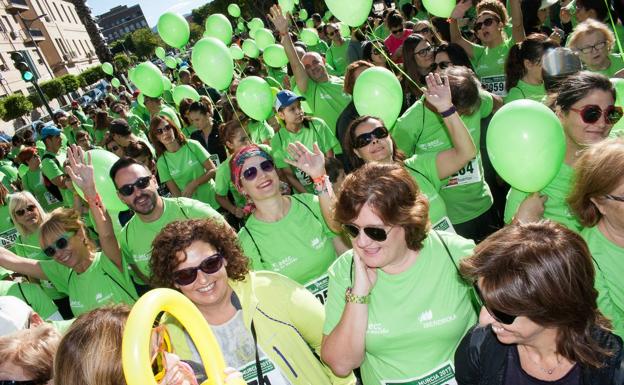 Miles de murcianos ataviados con camisetas verdes recorren la Gran Vía durante la segunda edición de la carrera 'AECC en Marcha Murcia Iberdrola'.