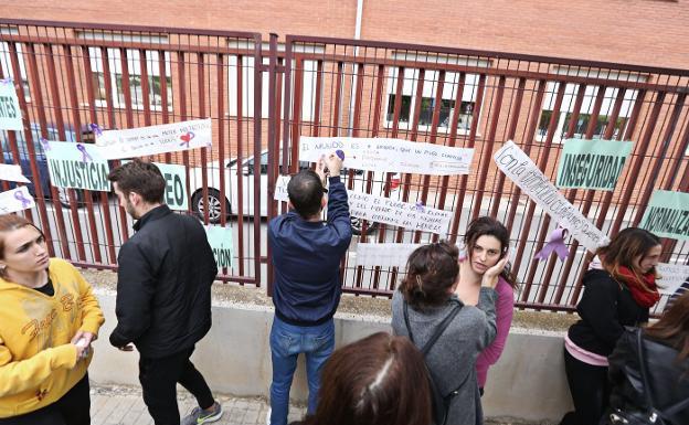 Jóvenes pegan carteles de repulsa junto al lugar del crimen.