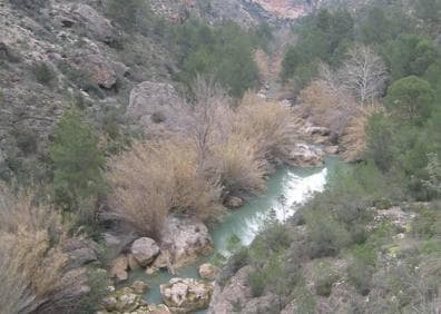 Imagen secundaria 1 - Un senderista se asoma al cauce del río sobre la zona conocida como La Badina, el río encajonado desde La Mulata y un cartel informativo.