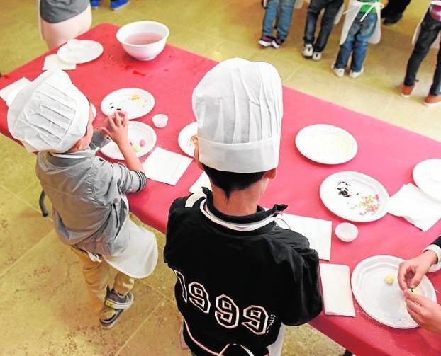 Dos niños preparan papitas venezolanas.