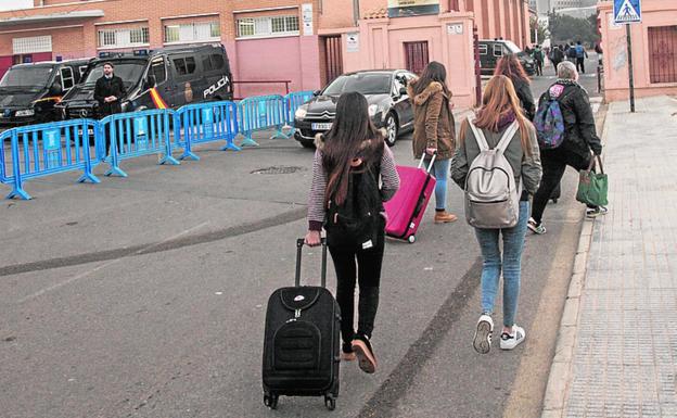 Alumnos entran al instituto Santa Lucía, en Cartagena, junto a la valla de protección policial. 