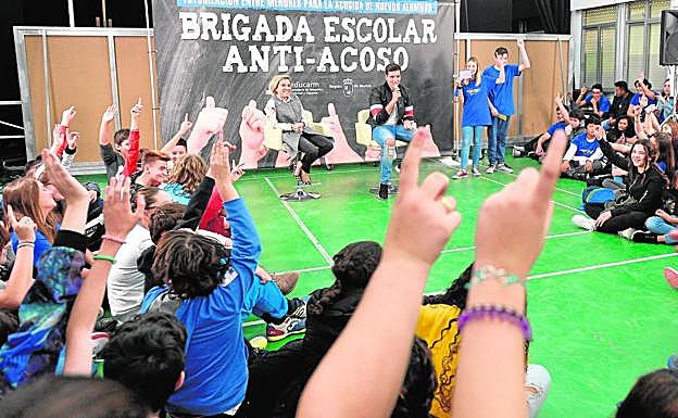 El cantante Xuso Jones, con la consejera de Educación, al fondo, con los alumnos del instituto Ramón y Cajal de Murcia.