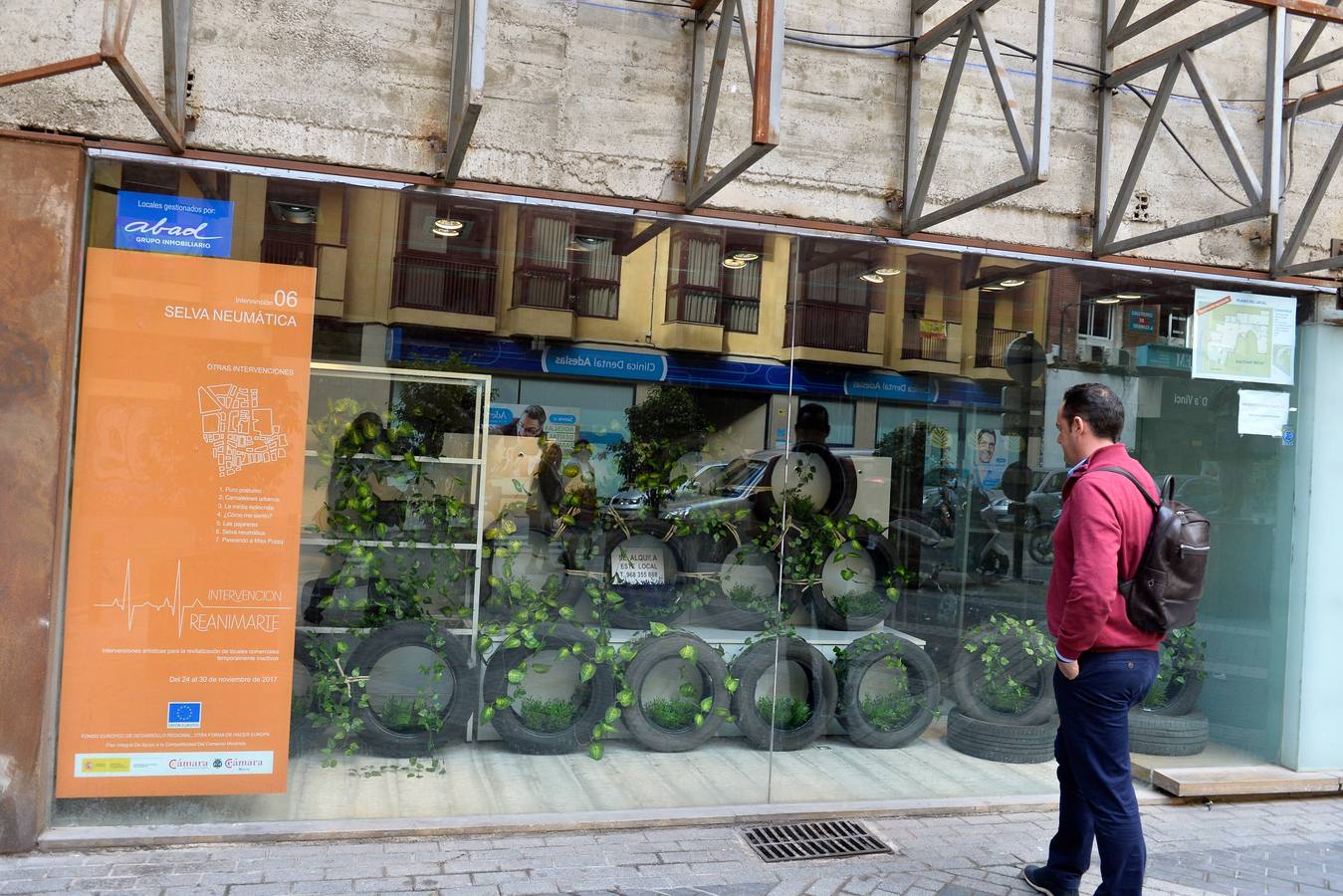 Un bodegón con muñecos dorados articulados, unas pajareras llenas de cascabeles o un montón de neumáticos decorados con plantas enredaderas son algunas de las propuestas de la arquitecta Helia San Nicolás que ha reconvertido los escaparates de siete comercios de la ciudad