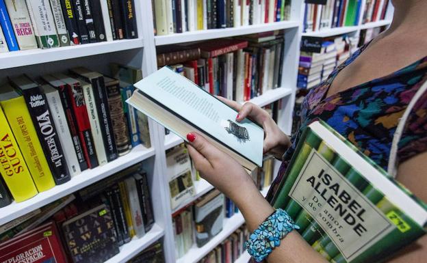 Una mujer sostiene un libro, en una fotografía de archivo.