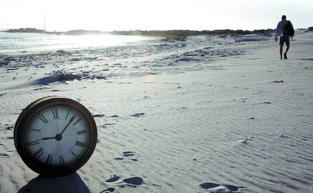 Reloj sobre la arena de la playa. 