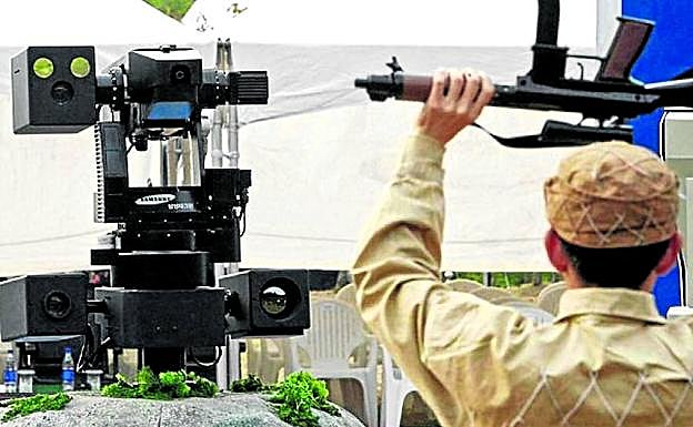 Un soldado de Corea del Sur realiza una demostración ante un robot de la frontera. 