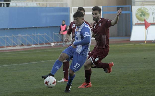 El 'loco' Alonso maneja el balón ante la presión de dos jugadores del Badajoz.