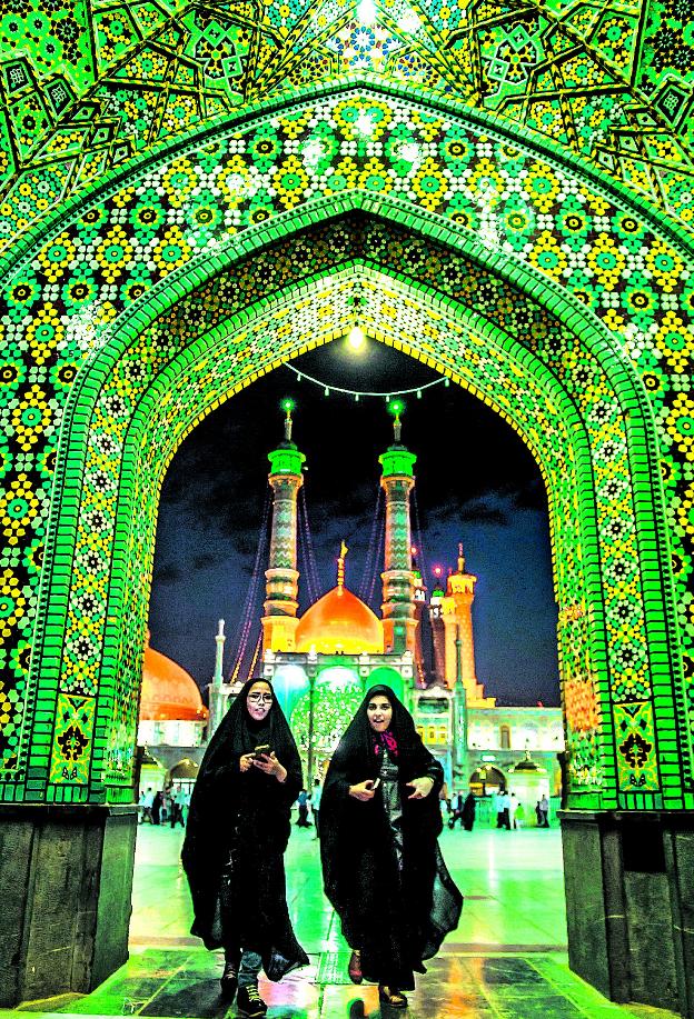 Lugares santos. Dos mujeres abandonan entre azulejos de colores la monumental plaza de Hazrat Masoumeh, un emblema para los musulmanes chiíes.