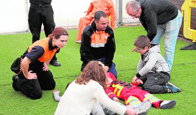 Unos niños realizan uno de los talleres de primeros auxilios.