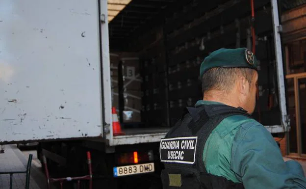 Un agente custodia la carga de un camión con droga para destruir.