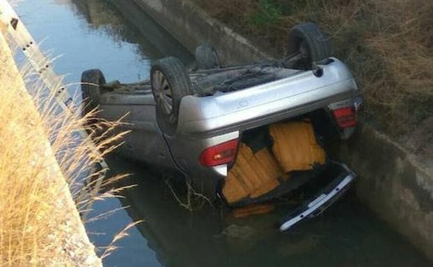 El coche volcado en la acequia.