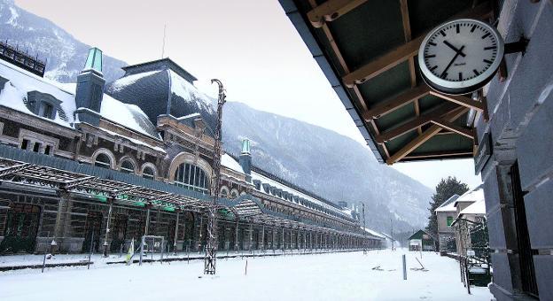 Un reloj preside el apeadero, que recibe y despide cuatro trenes diarios en la actualidad. Enfrente, el imponente edificio que albergará el hotel de cinco estrellas.