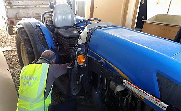 Un agente de la Guardia Civil inspecciona el tractor robado en Cieza.