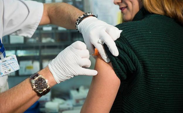 Una mujer recibe la vacuna de la gripe. 