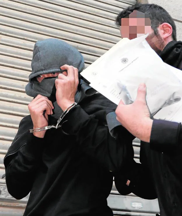Un policía acompaña al jugador que quedó detenido en Murcia por el presunto amaño de partidos.